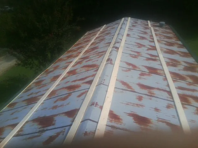 Rusted metal roof panels with new wood purlins before replacement — Storm Damage Roof Repair in New Cambria by Roofing Brothers