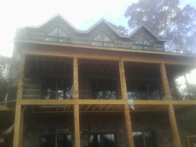 Dormers and porch framing on a large log home under construction in New Cambria